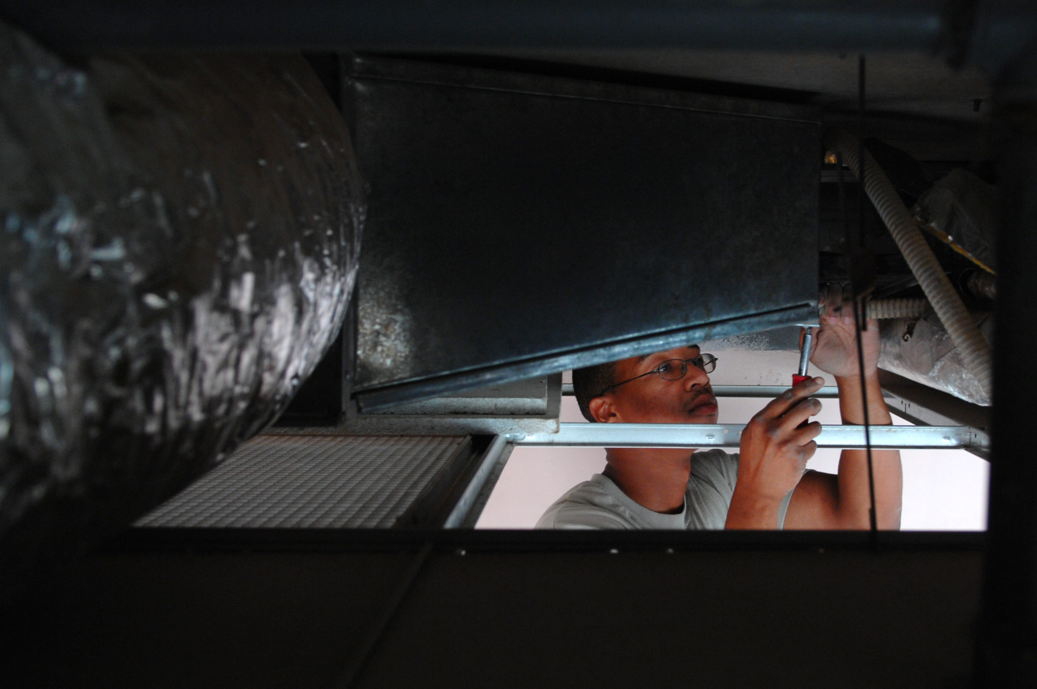U.S._Air_Force_Staff_Sgt._Gregory_Norris_attaches_a_hose_to_a_water_pipe_while_troubleshooting_a_malfunctioning_air_conditioning_unit_on_Balad_Air_Base