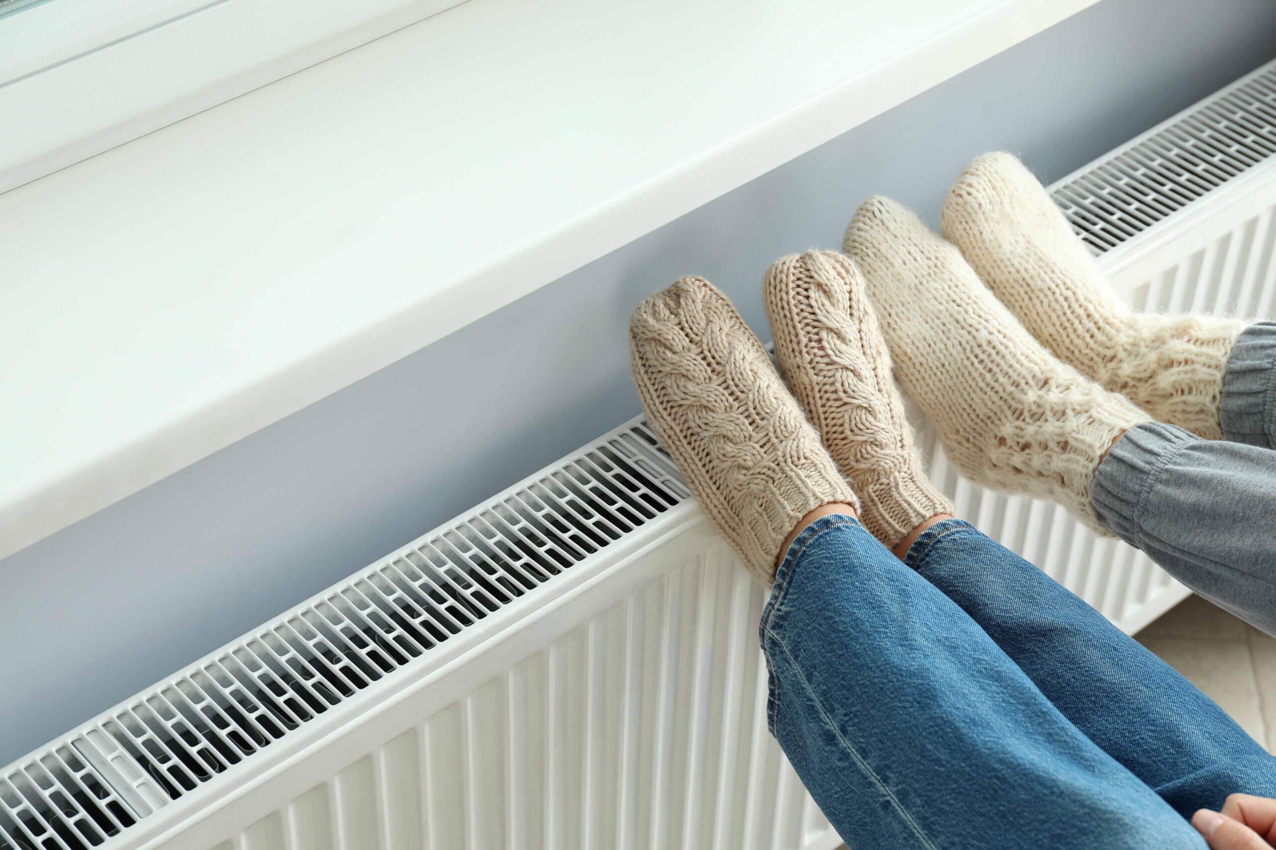Pair of feet in thick wool socks propped up on heater